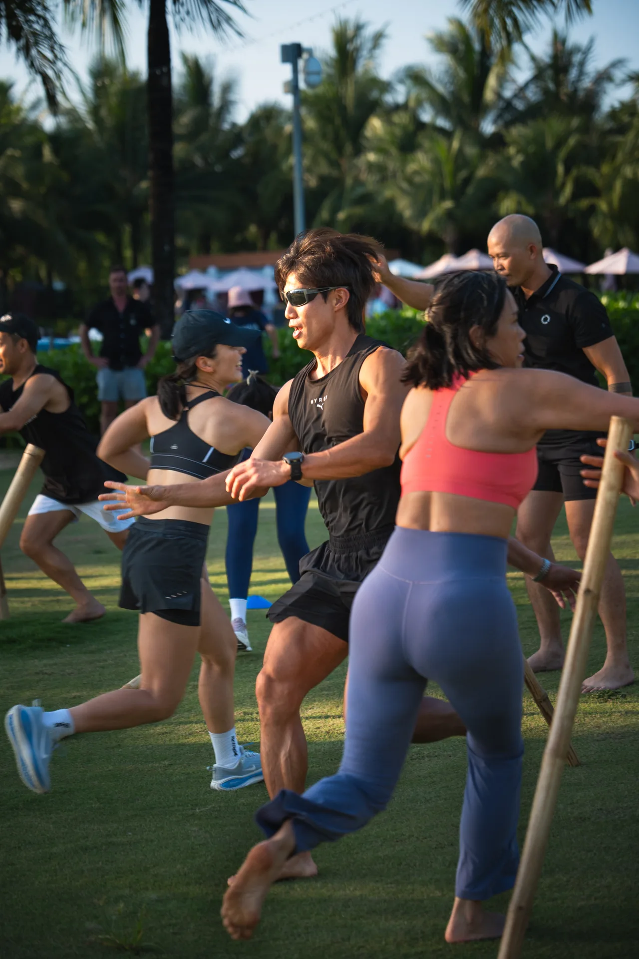 Outdoor group HIIT under palms at golden hour